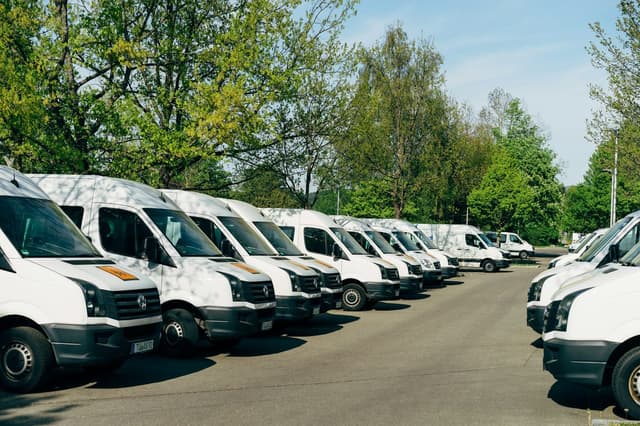 Rangée de fourgons blancs sur un parking