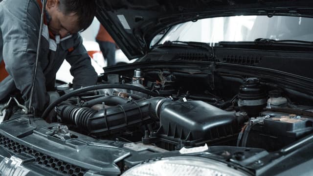 Mécanicien penché sur le moteur d’une voiture