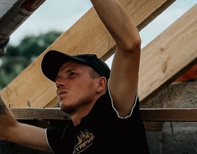 Artisan posant un écran de sous-toiture entre les chevrons