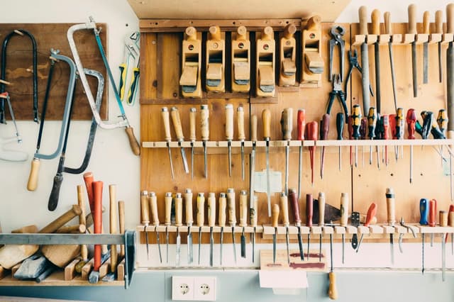 Outils à main rangés sur le mur d’un atelier