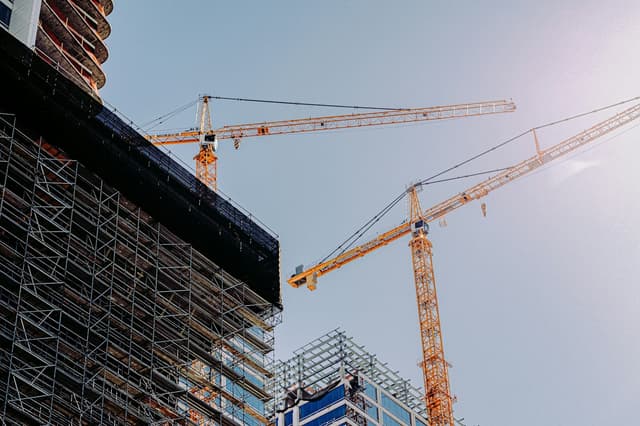 Grues à tour au-dessus d’un immeuble en chantier